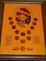 Framed Lincoln coin collection with twelve pennies arranged around an illustration of Abraham Lincoln and flag.