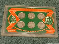 Front of hard plastic display case showing six Buffalo Indian Head nickels with orange and green artwork depicting Native American heads.