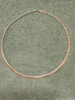 Sterling silver necklace displayed flat on green fabric surface.