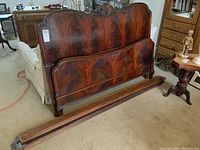 Full view of wooden double bed frame headboard, footboard, and side rails showcasing wood grain and carvings
