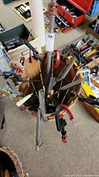 Top-down view of a variety of metal and plastic clamps arranged radially in a wooden basket.