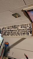 Wide view of a wall-mounted board covered with multiple rows of skeleton keys hung by size and style