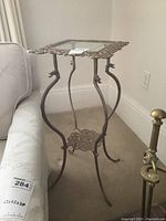 Full view of the vintage metal fern stand with glass top, showing the detailed metal frame and curved legs.