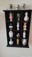 Full view of the wooden shelf with miniature vases in compartments