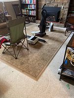 Full view of the patterned area rug with household items on top, showing overall layout and size.