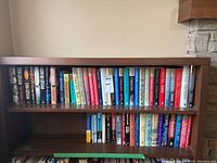 Bookshelf showing a broad collection of novels including legal thrillers and romance genres.