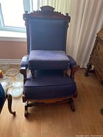 Front view of Eastlake style rocking chair with matching footstool, showing upholstery and wooden frame.