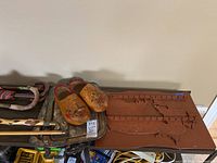 Photo showing wooden spoon rack shaped like map of Canada, painted wooden shoes, silver plate trays, and canes.