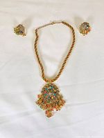 Photo of the full bridal jewelry set including necklace and earrings laid flat on white background.