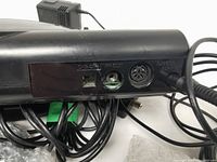 Back of Sega Genesis console showing AV OUT, RF OUT, POWER, and A/V OUT adapter ports with cords attached.