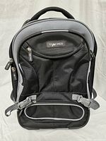 Front view of black and gray Tracker rolling luggage showing multiple zipped compartments and padded handle