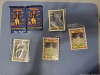 Image showing two unopened packs of The McDonald's 500 baseball cards and five other packs of vintage baseball cards, some sealed in plastic and some opened but grouped.