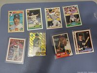 Nine baseball cards from various players and brands laid out on a dark blue surface. Includes All-Star, Hall of Fame and popular MLB players.