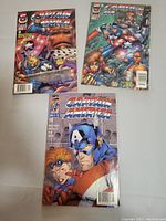 Photo showing three Captain America comic books laid out on a flat surface, each with different cover art.