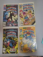 Four Captain America comic books laid out showing colorful illustrated covers