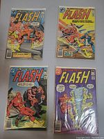 Photo showing all four Flash comic books laid out on surface with visible covers