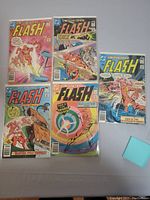 Five Flash comic books laid out on a flat surface showing their colorful covers.
