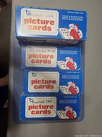 Four blue boxes of Topps baseball picture cards from 1987, 1988, 1989, and 1990, showing the year and branding on each box.