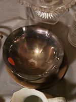 Silver-tone bowl with reflective finish, visible wear and a red sale sticker.