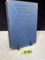 Front cover of the 1921 book 'The Conservation of the Wild Life of Canada' showing blue cloth hardcover with title and author embossed.