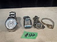 Photo of four vintage watches in a row showing different styles and bands including a classic Gruen watch with linked chain bracelet.