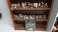 Full view of wooden shelf with seventeen assorted Boyds Bears figurines displayed on two shelves and the Friendship Flag package on bottom shelf.