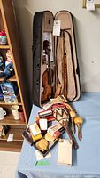 Overall view of the violas in cases, pan flutes, maracas, whistles, reeds, and record cleaning machine