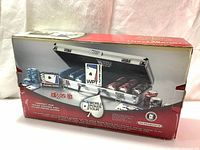 Box showing the full closed product packaging with image of poker set inside metal case and branding information.