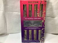 Front of the unopened gift set packaging showing 8 mini lip gloss tubes (4 on top row, 4 on bottom) and the Masquerade Eye Veil in the center