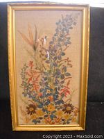 Full front view of the framed pressed flower art showing the entire composition inside the gold gilt frame.