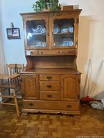 Full view of the solid wood china cabinet with lower drawers and upper glass hutch showing display area and hardware details.