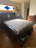 Full view of queen size wood platform bed with vinyl padded frame and mattress in bedroom setting