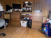Front view of solid wood desk with drawers, hutch on top, and corner shelf. Various items on desk and floor.