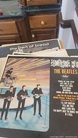 Vinyl albums including The Beatles 'Something New' with visible song list and cover art details.