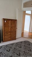 Full view of the Huntley by Thomasville armoire showing the wood grain and door design.