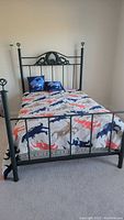 Full view of the assembled metal bed frame with dinosaur bedding in a carpeted room.