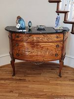 Front view of three-drawer marquetry cabinet with black marble top