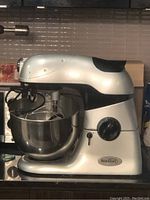 Side profile of the silver Beaumark stand mixer showing mixing bowl attached and overall body design.