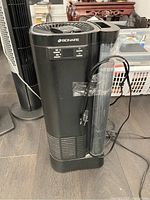 Front angled view of black Bionaire humidifier showing control buttons, vented top, and attached power cord.