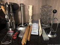 Overview of the kitchen utensils, tools, and accessories in the lot arranged on a countertop.