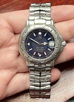 Front view showing navy blue dial, bezel and bracelet links