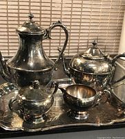 Overall view of coffee pot, tea pot, creamer, sugar bowl on silver plated tray