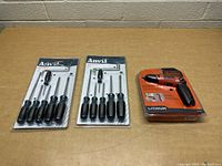 Photo of two Anvil screwdriver sets and one Black & Decker electric screwdriver on tabletop, all new in packaging.