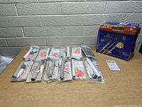12 individual rocket kits laid out on a table with packaging and a sealed bulk pack box visible