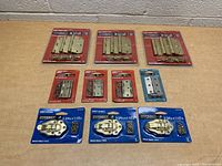 Photo shows full lot of assorted hinges in original packaging arranged on table, displaying multiple packs of Everbilt Hinge Project Packs and smaller hinges with screws.