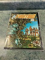 Photo of Fugitoid #1 comic book front cover showing robot and human soldiers in jungle scene, slightly worn edges visible.