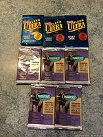 Photo of 3 sealed Fleer Ultra and 5 sealed Parkhurst 1993-94 NHL hockey card packs laid flat on surface.