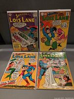 Four vintage Lois Lane comic books displayed side by side showing front covers.