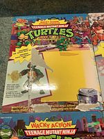 Photo showing Michaelangelo toy card back with Wacky Action logo, character images, and text describing motorized action features