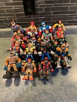 Lot of 19 mixed shape action figures arranged standing and sitting showing condition and wear
